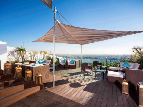 a patio with a canopy and chairs on a deck at Sofitel Casablanca Tour Blanche in Casablanca
