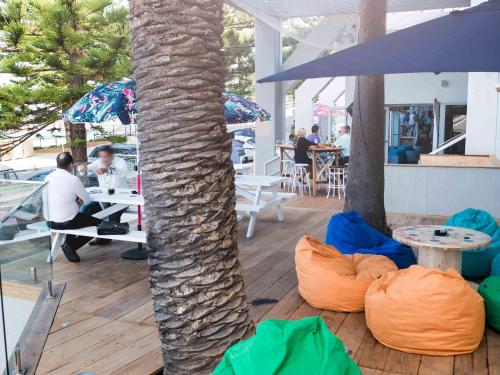 a room with a palm tree and bean bags at Novotel Wollongong Northbeach in Wollongong
