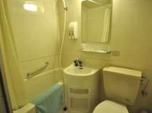 ein Badezimmer mit einem weißen WC und einem Waschbecken in der Unterkunft Green Hotel Shimonoseki in Shimonoseki