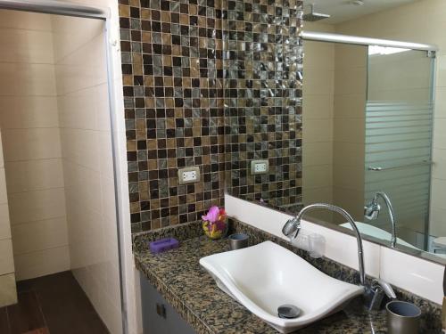 ein Badezimmer mit Waschbecken und Spiegel in der Unterkunft Habitaciones en Buena Vista in Lima