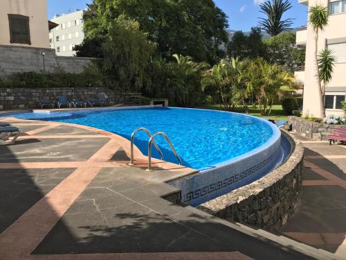 a large swimming pool with a stone wall around it at Funchal Apartment, with pool in Funchal