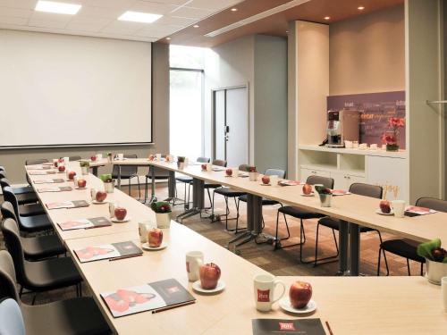 a large room with tables and chairs and a whiteboard at Ibis Casa Voyageurs in Casablanca