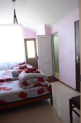 a bedroom with two beds with red pillows at Alex's Cosy Guesthouse in Tbilisi City