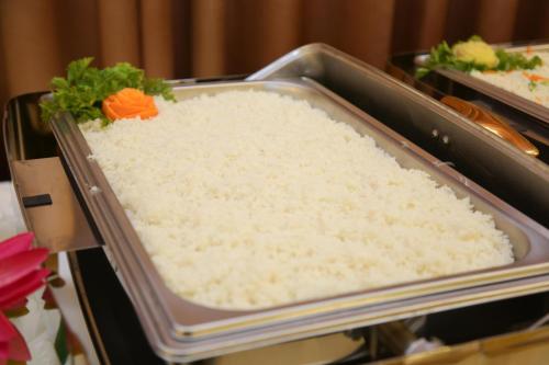 a tray of white rice with a flower on top at Agbo Hotel in Polonnaruwa