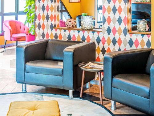 a lobby with two blue chairs and a table at Ibis Styles Reims Centre in Reims