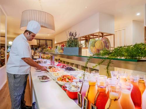 a chef preparing a buffet of food in a kitchen at Pullman Brisbane King George Square in Brisbane