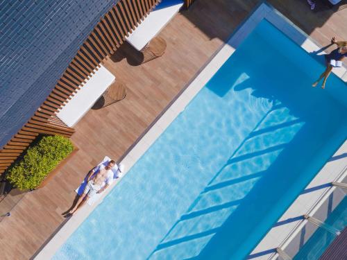an overhead view of a swimming pool with people in it at Pullman Brisbane King George Square in Brisbane