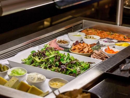 a buffet filled with different types of vegetables and other foods at Pullman Brisbane King George Square in Brisbane
