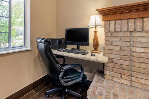 a computer desk with a computer monitor and a chair at Comfort Suites Fort Collins Near University in Fort Collins