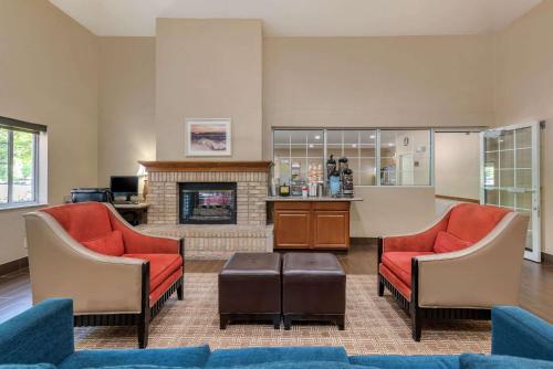 a living room with two chairs and a fireplace at Comfort Suites Fort Collins Near University in Fort Collins