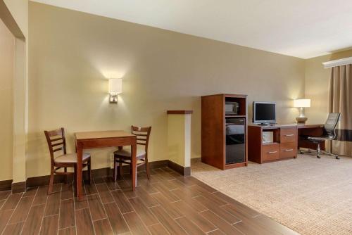 a hotel room with a table and chairs and a television at Comfort Suites Fort Collins Near University in Fort Collins