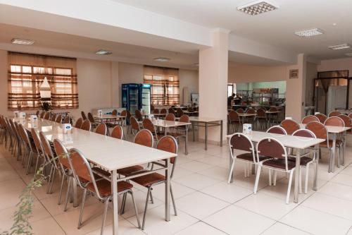 een eetkamer met tafels en stoelen bij GYM Inn in Tasjkent