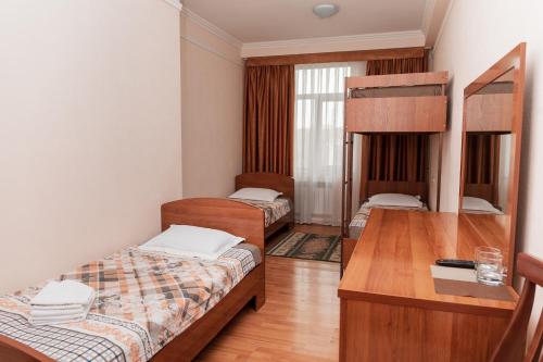 a room with two bunk beds and a desk at GYM Inn in Tashkent