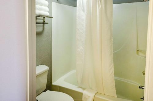 a bathroom with a toilet and a shower curtain at Rodeway Inn Panama City in Panama City