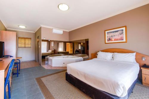 a bedroom with a large bed and a bathroom at Quality Inn Penrith Sydney in Penrith