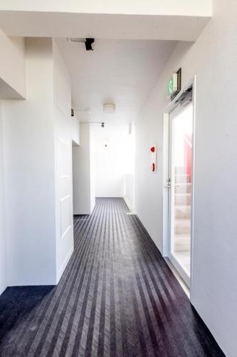 an empty corridor with an open door in a building at Hote Io Lite in Nago