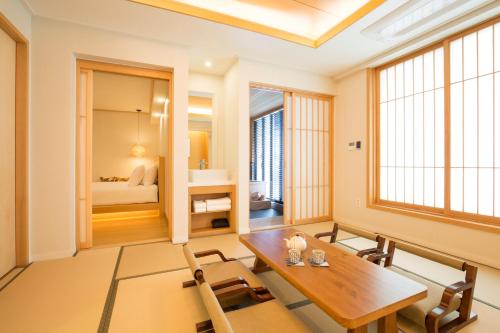a dining room with a table and a bedroom at Tomonoya Ryokan Geoje in Geoje