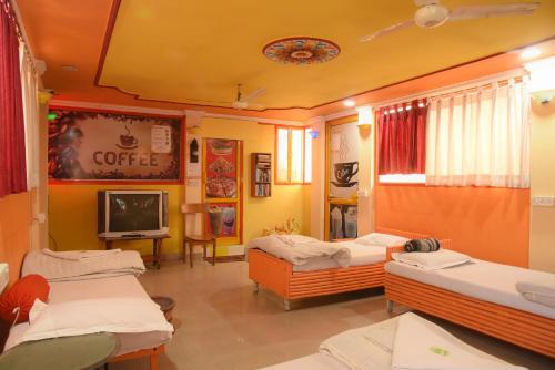 a hospital room with three beds and a tv at Govind Hotel in Jodhpur