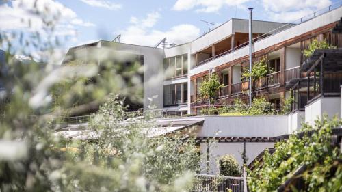 an apartment building with plants on the balconies at Biohotel theiner's garten in Lana