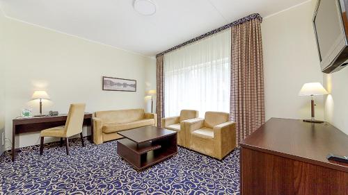 a hotel room with a desk and a living room at Medical SPA "Eglės sanatorija" Comfort Druskininkai in Druskininkai