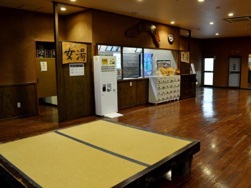 a room with a large yellow floor in a store at Tabinoyado Asonoyu in Aso