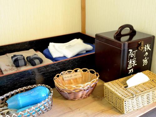a shelf with wicker baskets and a box on it at Tabinoyado Asonoyu in Aso