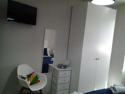 a bedroom with a white dresser and a chair and a mirror at Appartamento Galeotti 18 in Gubbio