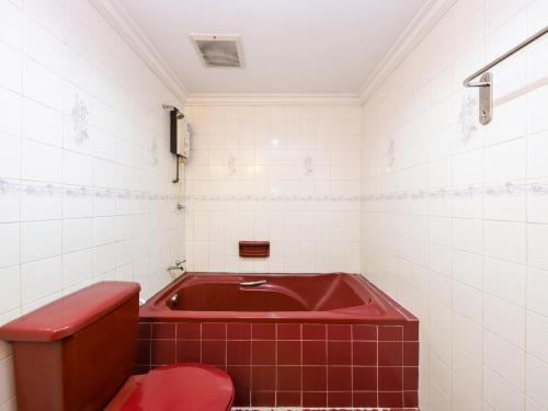baño con bañera roja y aseo rojo en OYO 472 Comfort Hotel 1 en Klang