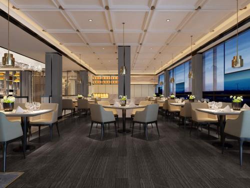 西哈努克的住宿－Ocean Delight Boutique Hotel 海悦精品酒店，用餐室设有桌椅和窗户。