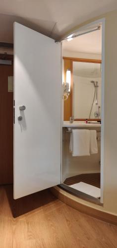 a bathroom with a glass door with a sink at ibis Bengaluru City Centre - An Accor Brand in Bengaluru