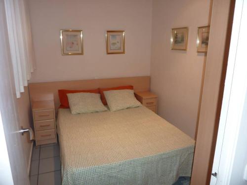 a small bedroom with a bed and two pillows at Primera Linea de Mar Portaventura in Salou