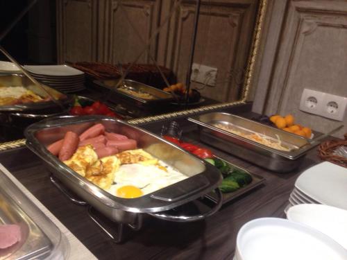 a kitchen with a breakfast buffet with eggs and vegetables at Hotel Villa Natali in Chişinău