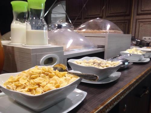 a buffet with bowls of food on a table at Hotel Villa Natali in Chişinău