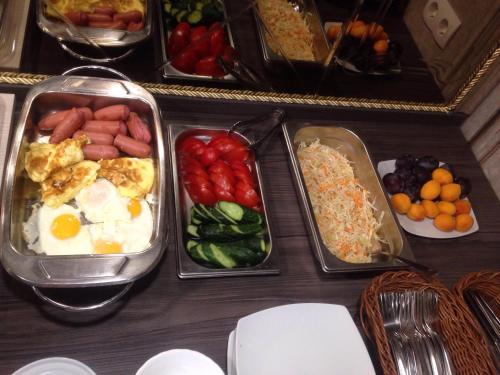 a table topped with trays of food with eggs and vegetables at Hotel Villa Natali in Chişinău