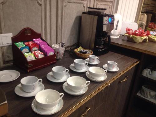 a table with tea cups and saucers on it at Hotel Villa Natali in Chişinău