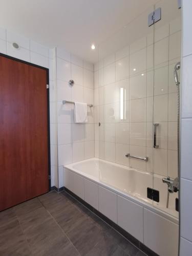 a large bathroom with a tub and a shower at Radisson Blu Hotel, St. Gallen in St. Gallen