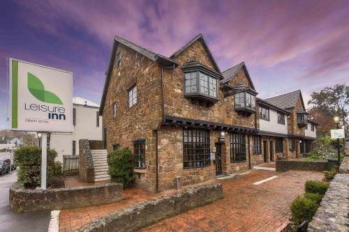 a large brick building with a sign in front of it at Leisure Inn Penny Royal Hotel & Apartments in Launceston