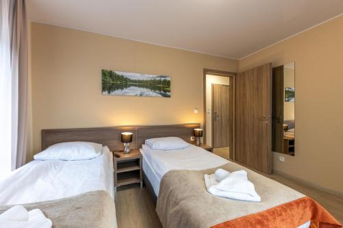 a hotel room with two beds and a mirror at Przystanek Alaska in Zieleniec