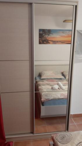 a mirror next to a bed in a bedroom at Apartmani Lupi 2 M&S in Vrboska