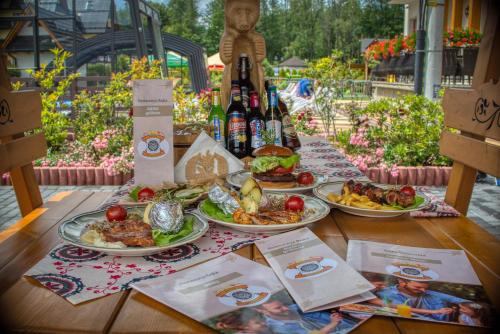 a table with plates of food and bottles of wine at Hotel Liptakówka in Białka Tatrzanska