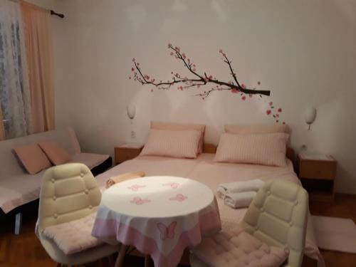a bedroom with a bed with a table and chairs at Apartments Garden in Rovinj