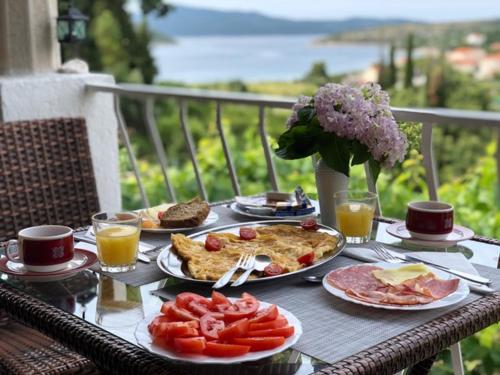 a table with plates of food and drinks on it at Vila Mozara in Slano