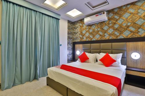 a bedroom with a large bed with red pillows at Esfrine Hotel Apartment in Tabuk