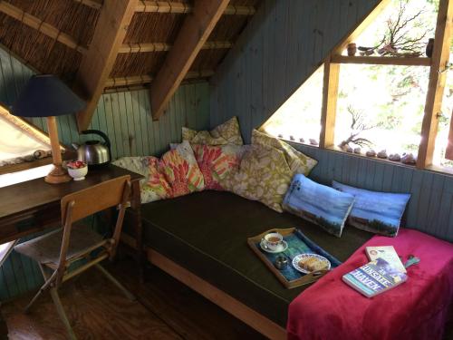 een kamer met een bed en een tafel met een bord eten bij Driftwood Treehouse in Sunrise-on-Sea