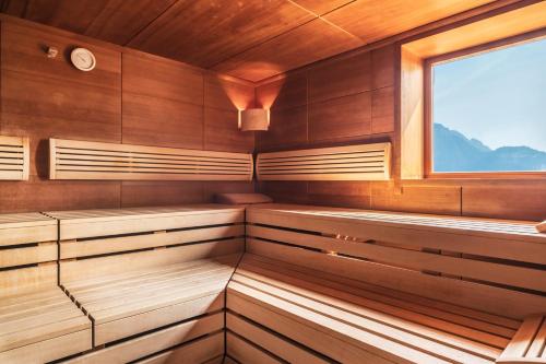a sauna with wooden cabinets and a window at SOLEA DOLOMITI Boutique Hotel in Fai della Paganella