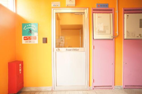 an entrance to a room with colorful doors at Plusone Fujisaki in Fukuoka