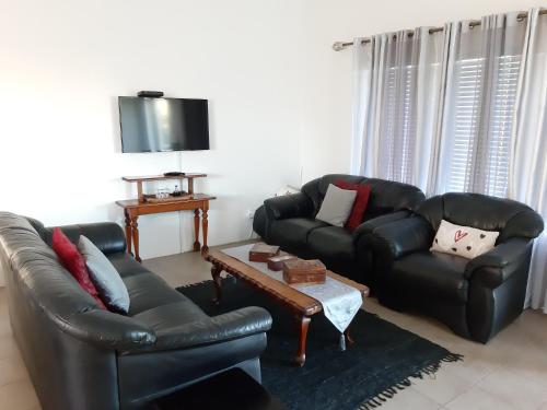 a living room with two leather couches and a coffee table at Lieflappie❤ in Stilbaai