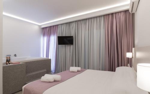 a hotel room with a bed and a bath tub at Poseidonio Hotel in Tinos Town