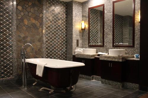 a bathroom with two sinks and a bath tub at Shengyi Holiday Villa Hotel in Sanya