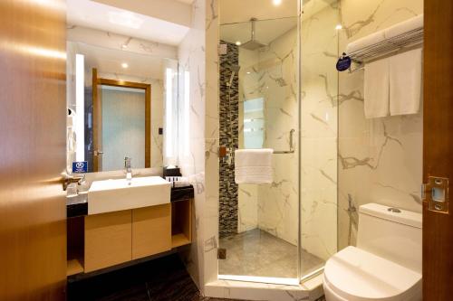 a bathroom with a toilet and a sink and a shower at Best Western Plus Metro Clark in Angeles